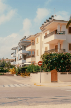 Row of white apartment buildings next to a street