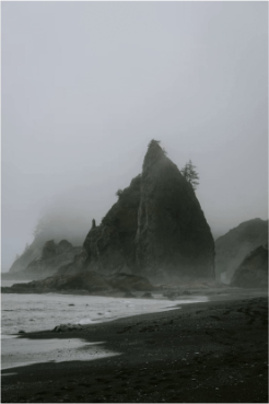 Foggy beach with large rock formation