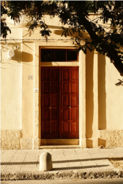 Building with a red door and a tree in front